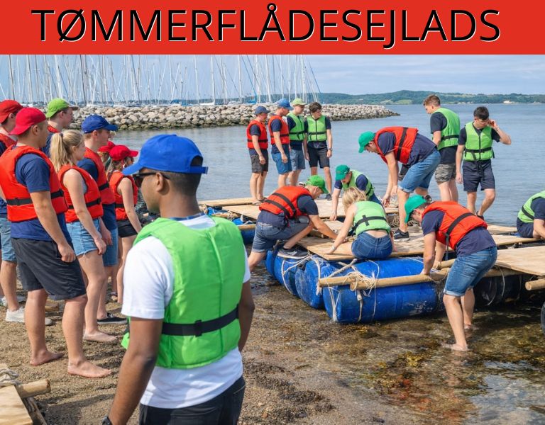 Billedet viser deltagere, der i fællesskab bygger og klargør en tømmerflåde ved vandkanten iført redningsveste. Motivet signalerer samarbejde, problemløsning og aktiv teambuilding i maritime omgivelser.